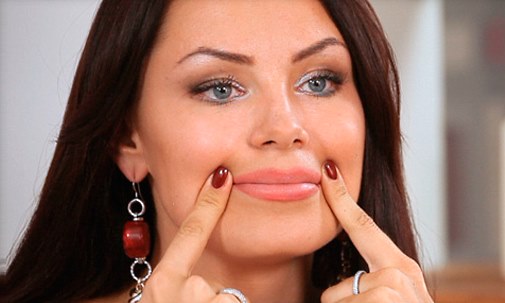 Женщина держит указательные пальцы на уголках рта