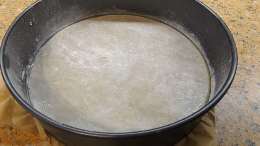 Начинаем приготовление диетической шарлотки с того, что смазываем форму маслом и посыпаем ее сахарной пудрой