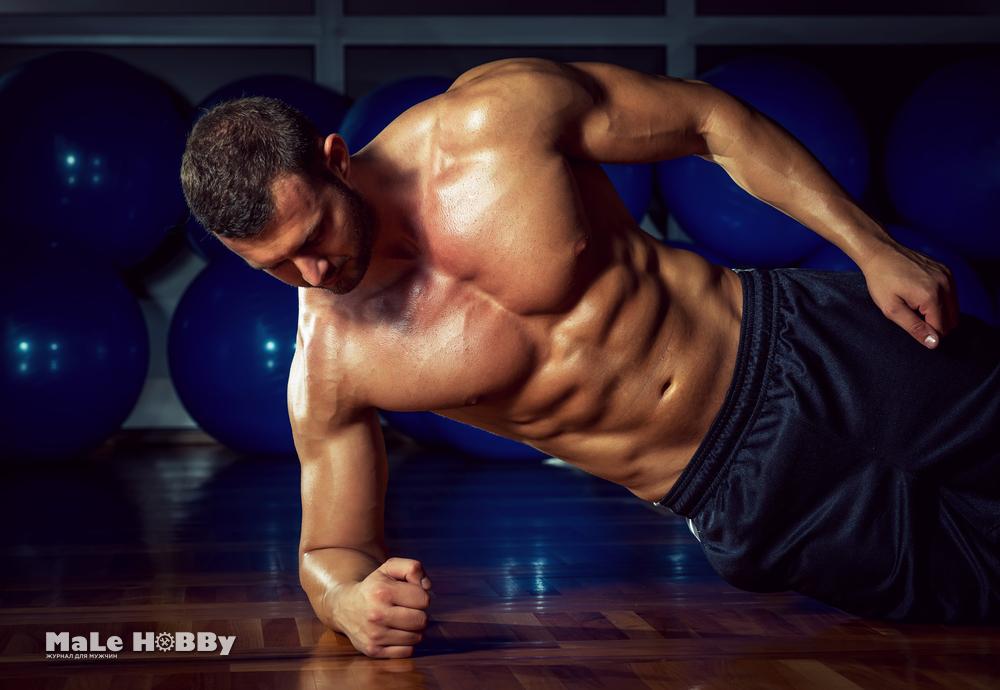 Man doing side plank exercise in gym