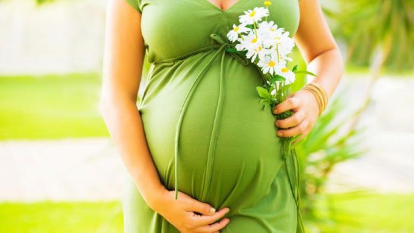Беременная женщина в зеленом платье