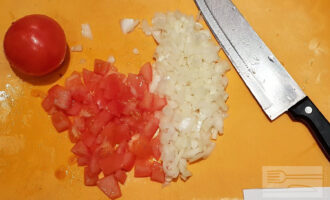 Шаг 2: Лук и помидоры нарежьте мелкими кубиками. 