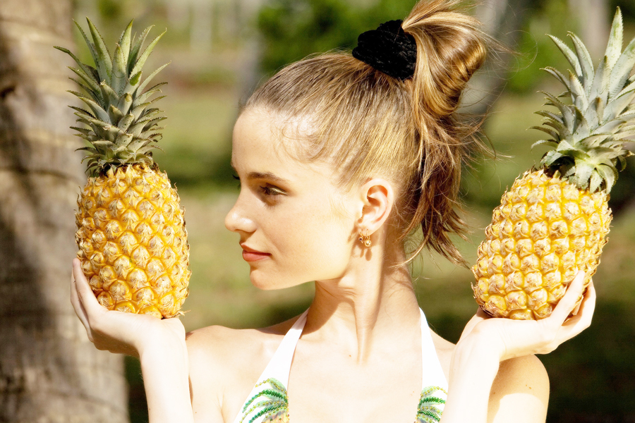 девушка держит ананасы