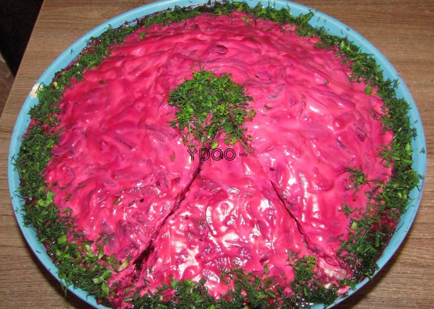 салат селедка под шубой на большом блюде, украшенный мелко нарезанным укропом